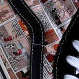 Championes de caña alta Vans modelo Sk8-HI, con diseño estampado de historietas de Condorito en los laterales. Presentan puntera y talón de gamuza negra, cordones blancos y suela de goma vulcanizada con la clásica franja lateral de la marca.