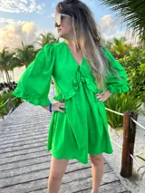 Vestido corto verde manzana de lino, con escote en V con volados y mangas abullonadas.