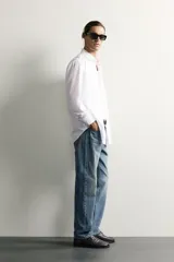 Camisa slim fit de Zara confeccionada en tejido de algodón con textura estructurada, cuello clásico con solapa y manga larga con puños abotonados. Cierre frontal con botonadura.