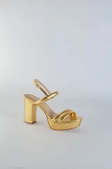 Sandalia de cuero con plataforma y taco cuadrado alto. Presenta una tira delgada en el tobillo con cierre de hebilla metálica y dos tiras acolchadas en la parte frontal.