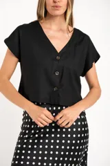Camisa negra corta de lino y viscosa, con calce oversize, escote en V y cierre frontal con botones.