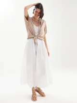 Vestido largo blanco de breteles finos, corte holgado y escote redondo. Incluye dos collares de cuentas y sandalias bajas con tiras.