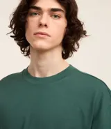 Remera de corte relaxed, confeccionada en algodón de tejido grueso con cuello redondo y mangas cortas.