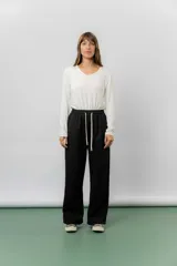 Pantalón deportivo de corte wide leg con caída relajada. Presenta cintura elastizada con cordón ajustable, bolsillos laterales y un interior frizado para mayor abrigo.