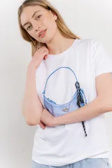 Remera blanca de algodón con estampado de un bolso con llavero colorido.