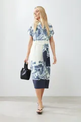 Vestido midi color blanco con estampado de paisley en azul y cinturón de lazo.