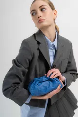 Cartera tipo sobre de cuero color fucsia, con diseño fruncido y cierre de cordón. Incluye una correa ajustable y extraíble para usarla como cartera o como sobre de fiesta.