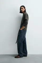 Camiseta relaxed fit color gris oscuro, confeccionada en tejido ligero de algodón con elasticidad. Presenta cuello redondo y manga ranglán corta.