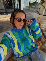 Buzo tejido de punto con rayas verticales en tonos azul, verde y amarillo, cuello redondo y mangas largas.