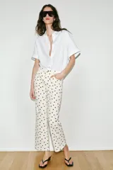 Jeans de tiro medio con diseño de cinco bolsillos, corte mini flare y bajo evasé. Presenta un estampado de lunares en contraste.