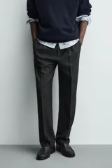Pantalón de vestir regular fit color negro, con pliegues frontales y cierre con cremallera y botón.