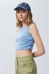 Top cropped celeste sin mangas y cuello a la base, con frunces en ambos laterales y textil lavado.