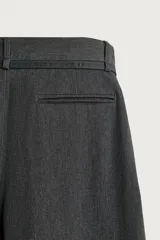 Pantalón de corte balloon fit confeccionado en tejido con viscosa. Presenta cintura ajustable con cinturón integrado, pliegues frontales, bolsillos laterales y bolsillos traseros de doble vivo. Cierre frontal con cremallera y botón.