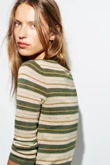 Jersey de punto fino con diseño a rayas horizontales en tonos tierra, bordó y celeste. Presenta cuello redondo, cierre frontal con botones y mangas por debajo del codo.