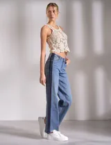 Jean wide leg de tiro medio-alto, color azul con franja vertical en denim oscuro en los laterales. Cuenta con cinco bolsillos y pretina con pasadores, botón y cierre.