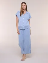Pantalón crop de textura tramada tipo denim lavado, de calce limpio y caída fluida, con cintura elástica, bolsillos laterales y silueta ancha y recta.
