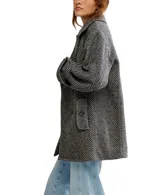 Abrigo tipo peacoat con diseño oversize y patrón de espiga. Presenta cuello clásico, cierre frontal de doble botonadura y silueta estructurada.