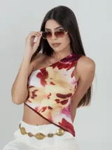 Top asimétrico de un solo hombro con estampado floral en tonos bordó, amarillo y blanco.
