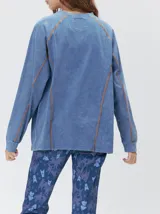 Remera de manga larga MUTMA Sticha, color negro con efecto acid wash y costuras decorativas expuestas en color celeste brillante. Cuenta con corte clásico, cuello redondo a la base y calce holgado.