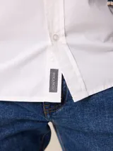 Camisa de manga larga en color blanco, confeccionada en algodón. Presenta cuello abotonado, cierre frontal con botones y un bolsillo en el pecho.