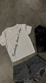 Remera negra de corte ajustado, con mangas cortas y estampa frontal diagonal con texto en color blanco.
