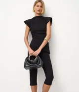 Pantalón capri negro de malla crepé, con pliegues delanteros y sin estampado.