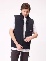Chaleco reversible de nylon con diseño acolchado, cuello alto y cierre frontal. Cuenta con un bolsillo con cierre en el pecho y bolsillos laterales, además de una etiqueta con el logo de la marca.