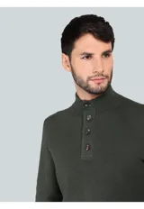Sweater de punto color azul marino, con cuello alto y cierre frontal parcial de botones. Presenta puños y ruedo acanalados.