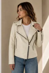 Campera estilo motoquera confeccionada en cuero ovino color marfil, con solapas amplias, cierre frontal cruzado, bolsillos con cierre y detalles de broches metálicos.