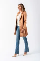 Blazer beige de poliéster con corte entallado, terminaciones impecables, bolsillos funcionales y forro interior suave.