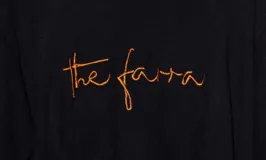 Sweater de punto color rosado con cuello redondo, mangas largas y el logo 'the farra' bordado en el frente.