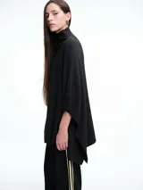 Poncho amplio de cuello alto, confeccionado en hilado con lana y cashmere, con diseño de caída recta y botones laterales.