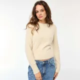 Sweater de punto fantasía en color beige, con cuello redondo y mangas largas. Presenta una textura suave y esponjosa, con un ajuste al cuerpo y puños acanalados.
