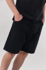 Bermuda cargo de algodón negro con calce relajado, bolsillos laterales aplicados y diseño utilitario.