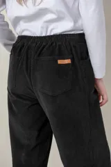 Pantalón de pana de algodón negro, de corte recto y holgado, con bolsillos laterales y traseros. Tiene elástico en la pretina trasera para mayor comodidad.