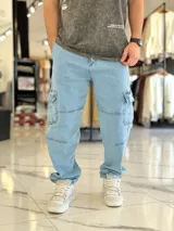 Pantalón cargo de jean color celeste claro, con bolsillos laterales con solapa en las piernas y corte holgado.