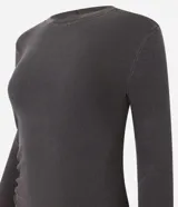 Vestido midi gris confeccionado en rib de algodón y elastano. Posee cuello redondo, manga larga y drapeado lateral con abertura en la parte inferior.