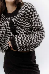 Buzo de punto grueso con diseño bicolor en patrón geométrico, de calce holgado y mangas largas.