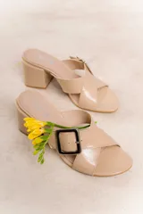 Sandalia color beige con tiras cruzadas y hebilla metálica cuadrada. Taco cuadrado de 6 cm.
