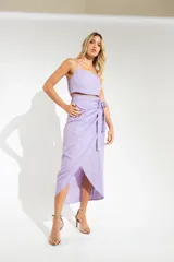 Pollera midi fucsia con corte irregular, abertura lateral y sistema de ajuste envolvente con lazo.