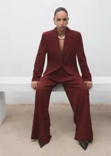 Chaqueta de traje color bordó con solapas de muesca, cierre frontal de un botón, bolsillos con solapa y forro interior.