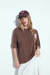 Remerón negro de manga corta, calce amplio y efecto gastado. Presenta una estampa gráfica de inspiración retro en el frente y la espalda.