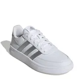 Championes Adidas Breaknet 2.0 de estilo urbano, color blanco con las icónicas tres tiras laterales y detalle en el talón en color plateado metalizado. Presentan un diseño de corte bajo con cierre de cordones y suela de goma plana.