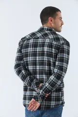 Sobrecamisa de algodón a cuadros color ladrillo, con interior de corderito, cierre con botones, bolsillos tipo cartera y logo en goma. El modelo usa talle M.