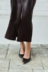 Falda midi de tiro alto con acabado efecto piel, diseño recto y abertura central en la parte trasera. Cuenta con cierre lateral mediante cremallera oculta.