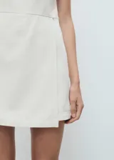 Vestido corto de algodón estilo denim con diseño sin mangas, tirantes finos, cuello escotado y cierre de cremallera lateral.