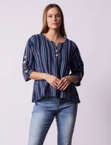 Blusa Erika de algodón azul marino con rayas verticales celestes y blancas. Presenta escote en V con botones decorativos en el frente y detalle de botones en las mangas cortas.