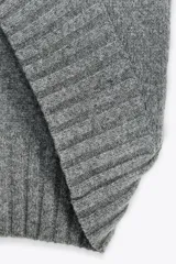 Chaleco oversize de lana color gris, con cuello redondo, manga sisa y bajo asimétrico con aberturas laterales.