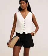 Short de mujer de sarga color beige claro, tiro alto, con pespunte contrastante en color blanco o crema. Presenta un corte regular y bolsillos delanteros y traseros.