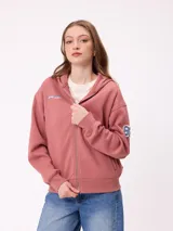 Canguro con cierre frontal, confeccionado en tejido de algodón y poliéster. Presenta capucha, bolsillos laterales, puños y ruedo acanalados. Incluye un pequeño logo bordado en el pecho y un aplique numérico en la manga.